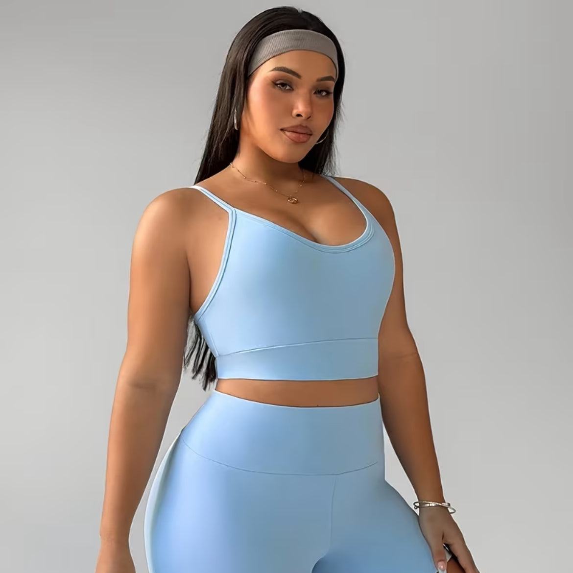Woman wearing a light blue athletic outfit on a gray background